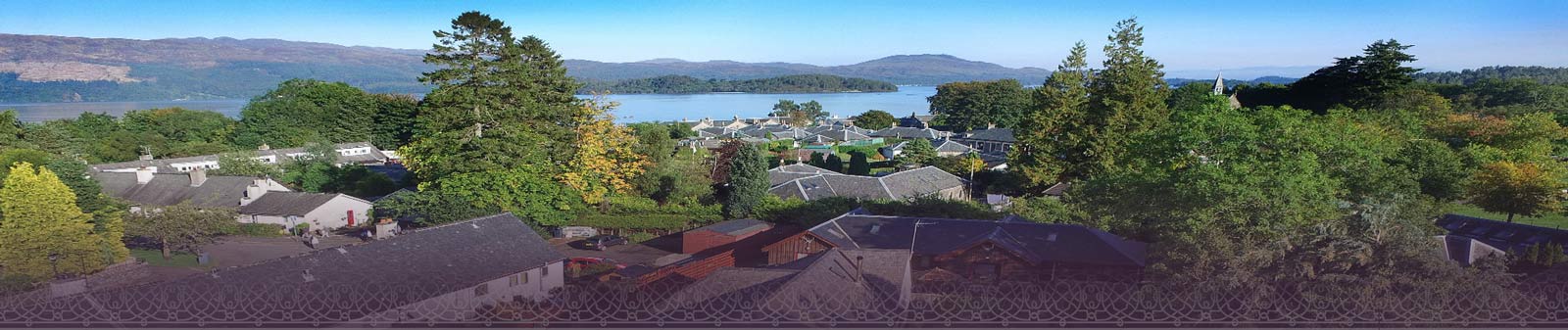 Birds eye view of Luss Village and Glenview Accomodation with Loch Lomond water in the background